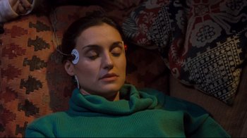 Movie still from “Freddy's Dead: The Final Nightmare” (1991), directed by Rachel Talalay – A woman wearing a green sweater and a white ear piece; Close Up shot, High angle