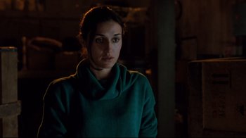 Movie still from “Freddy's Dead: The Final Nightmare” (1991), directed by Rachel Talalay – A woman wearing a green sweater in a dark room; Close Up shot, Over the shoulder angle