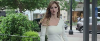 Movie still from “The Valet” (2022), directed by Richard Wong – A woman in a white dress walking down a street; Medium shot, Low angle