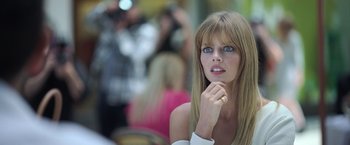 Movie still from “The Valet” (2022), directed by Richard Wong – A beautiful young woman with long blonde hair and blue eyes; Close Up shot, Over the shoulder angle