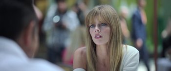 Movie still from “The Valet” (2022), directed by Richard Wong – A beautiful woman with long blonde hair and blue eyes looking at the camera; Close Up shot, Low angle
