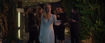 Movie still from “The Valet” (2022), directed by Richard Wong – A woman in a long white dress holding her hand out to a crowd; Medium shot, Over the shoulder angle