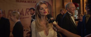 Movie still from “The Valet” (2022), directed by Richard Wong – A woman in a white dress being interviewed by a microphone; Close Up shot, Over the shoulder angle