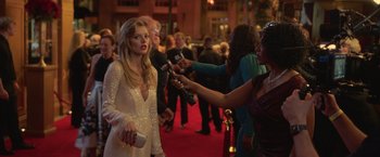 Movie still from “The Valet” (2022), directed by Richard Wong – A woman is being interviewed on a red carpet; Medium shot, Over the shoulder angle
