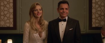 Movie still from “The Valet” (2022), directed by Richard Wong – A man and a woman posing for a picture; Medium shot, Low angle