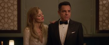 Movie still from “The Valet” (2022), directed by Richard Wong – A man in a tuxedo standing next to a woman in a white dress; Medium shot, Low angle