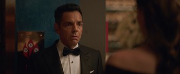 Movie still from “The Valet” (2022), directed by Richard Wong – A person wearing a suit and a bow tie; Close Up shot, Over the shoulder angle