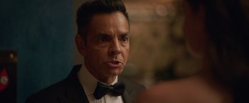 Movie still from “The Valet” (2022), directed by Richard Wong – A person wearing a suit and a bow tie; Close Up shot, Over the shoulder angle