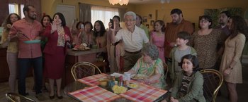 Movie still from “The Valet” (2022), directed by Richard Wong – An older man and a woman sitting at a dinner table; Medium shot, Over the shoulder angle