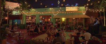 Movie still from “The Valet” (2022), directed by Richard Wong – A group of people sitting at tables in a restaurant; Extreme Wide shot, High angle