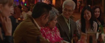 Movie still from “The Valet” (2022), directed by Richard Wong – An older man and a younger woman sitting next to each other; Medium shot, Over the shoulder angle