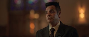 Movie still from “The Valet” (2022), directed by Richard Wong – A person wearing a suit and tie; Close Up shot, Low angle