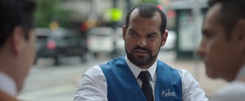 Movie still from “The Valet” (2022), directed by Richard Wong – A person wearing a vest and a tie; Close Up shot, Over the shoulder angle