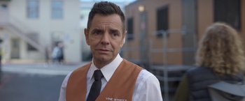 Movie still from “The Valet” (2022), directed by Richard Wong – A person wearing a vest and tie; Close Up shot, Over the shoulder angle