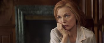 Movie still from “French Exit” (2020), directed by Azazel Jacobs – A person sitting with her hand on her chin; Close Up shot, Over the shoulder angle