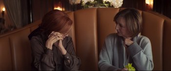 Movie still from “French Exit” (2020), directed by Azazel Jacobs – Two people sitting in a booth talking to each other; Medium shot, Over the shoulder angle