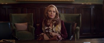 Movie still from “French Exit” (2020), directed by Azazel Jacobs – A woman sitting at a table with a purse in front of her face; Medium shot, Over the shoulder angle