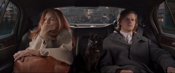 Movie still from “French Exit” (2020), directed by Azazel Jacobs – Two people in a car with a cat in the back seat; Medium shot, High angle