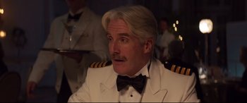 Movie still from “French Exit” (2020), directed by Azazel Jacobs – A person wearing a suit and tie; Close Up shot, Over the shoulder angle