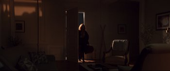 Movie still from “French Exit” (2020), directed by Azazel Jacobs – A person standing in a room with a suitcase; Wide shot, Over the shoulder angle