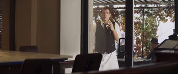 Movie still from “French Exit” (2020), directed by Azazel Jacobs – A man is taking a picture of himself in the mirror; Medium shot, Over the shoulder angle