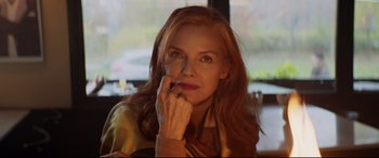 Movie still from “French Exit” (2020), directed by Azazel Jacobs – A person sitting at a table with her hand on her chin; Close Up shot, Low angle