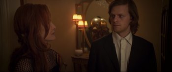 Movie still from “French Exit” (2020), directed by Azazel Jacobs – A man and a woman standing in front of a mirror in a room; Medium shot, Over the shoulder angle