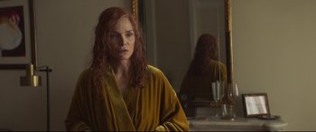 Movie still from “French Exit” (2020), directed by Azazel Jacobs – A woman with red hair looking into a bathroom mirror; Close Up shot, Over the shoulder angle