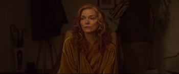 Movie still from “French Exit” (2020), directed by Azazel Jacobs – A woman sitting in a chair with long red hair; Close Up shot, Over the shoulder angle