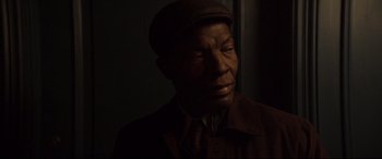 Movie still from “French Exit” (2020), directed by Azazel Jacobs – An older man wearing a hat and a tie; Close Up shot, Over the shoulder angle