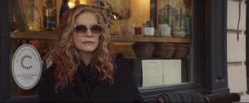 Movie still from “French Exit” (2020), directed by Azazel Jacobs – A woman sitting at a table in front of a window; Close Up shot, Over the shoulder angle