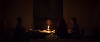 Movie still from “French Exit” (2020), directed by Azazel Jacobs – A woman sitting at a table with a lit candle; Medium shot, Over the shoulder angle