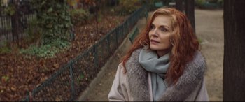 Movie still from “French Exit” (2020), directed by Azazel Jacobs – A woman with red hair wearing a coat and a scarf; Close Up shot, Over the shoulder angle