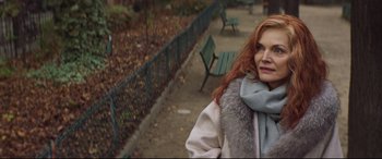 Movie still from “French Exit” (2020), directed by Azazel Jacobs – A woman with red hair wearing a white coat and a gray scarf; Close Up shot, Over the shoulder angle