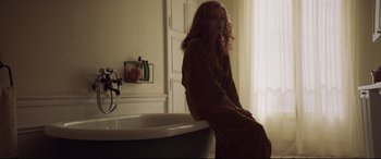 Movie still from “French Exit” (2020), directed by Azazel Jacobs – A woman sitting on a tub in a bathroom; Medium shot, Low angle