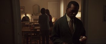 Movie still from “French Exit” (2020), directed by Azazel Jacobs – A man standing in front of two women in a living room; Medium shot, Over the shoulder angle