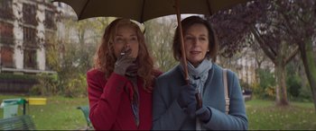 Movie still from “French Exit” (2020), directed by Azazel Jacobs – Two women standing next to each other under an umbrella; Medium shot, Low angle