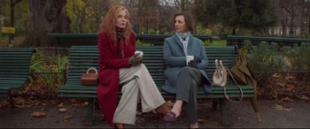Movie still from “French Exit” (2020), directed by Azazel Jacobs – Two women sitting on a park bench with a cup of coffee; Medium shot, Low angle
