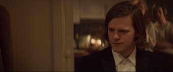 Movie still from “French Exit” (2020), directed by Azazel Jacobs – A man in a suit and white shirt looking at the camera; Close Up shot, Over the shoulder angle