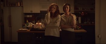 Movie still from “French Exit” (2020), directed by Azazel Jacobs – Two women standing next to each other in a kitchen; Medium shot, Low angle