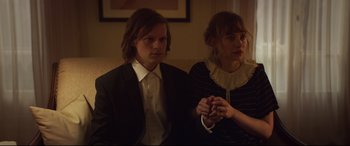Movie still from “French Exit” (2020), directed by Azazel Jacobs – A man and a woman sitting next to each other on a couch; Medium shot, High angle