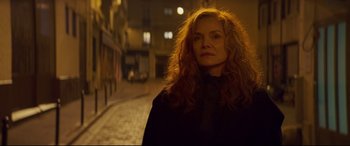 Movie still from “French Exit” (2020), directed by Azazel Jacobs – A woman standing on the side of a street at night; Close Up shot, Over the shoulder angle