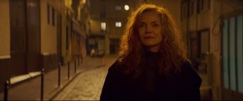 Movie still from “French Exit” (2020), directed by Azazel Jacobs – A woman standing on a street at night; Close Up shot, Over the shoulder angle