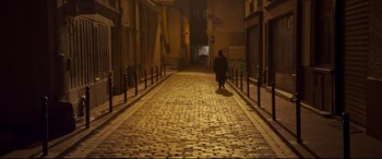 Movie still from “French Exit” (2020), directed by Azazel Jacobs – A person walking down a street at night; Extreme Wide shot, High angle