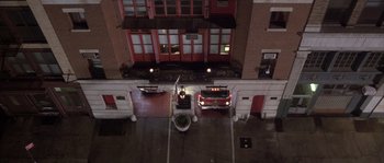 Movie still from “Frequency” (2000), directed by Gregory Hoblit – An aerial view of a fire truck parked in a parking lot; Extreme Wide shot, Overhead angle