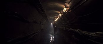 Movie still from “Frequency” (2000), directed by Gregory Hoblit – A person is walking in a dark tunnel; Wide shot, High angle