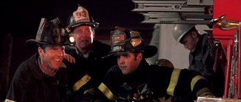 Movie still from “Frequency” (2000), directed by Gregory Hoblit – Two firemen sitting next to each other on a fire truck; Close Up shot, Low angle
