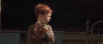 Movie still from “Frequency” (2000), directed by Gregory Hoblit – A young boy holding a baseball glove in his hands; Close Up shot, Over the shoulder angle