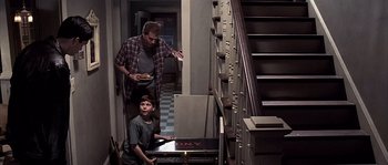 Movie still from “Frequency” (2000), directed by Gregory Hoblit – A man and a young boy in front of a filing cabinet; Wide shot, High angle