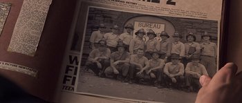 Movie still from “Frequency” (2000), directed by Gregory Hoblit – A black and white photo of a group of men in uniform; Extreme Close Up shot, High angle